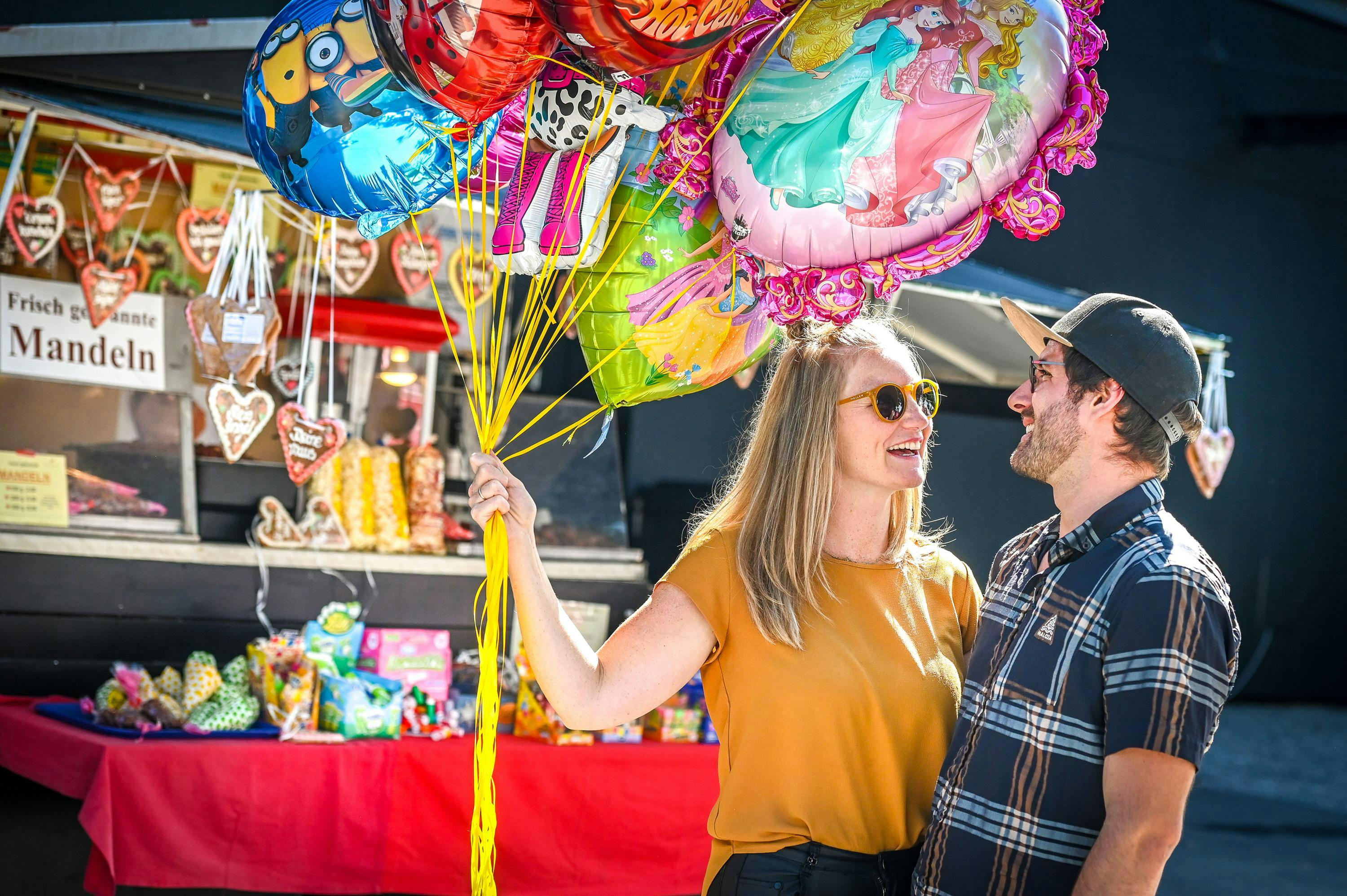 Paar mit Luftballons im Freigelände der Herbstmesse. © Udo Mittelberger